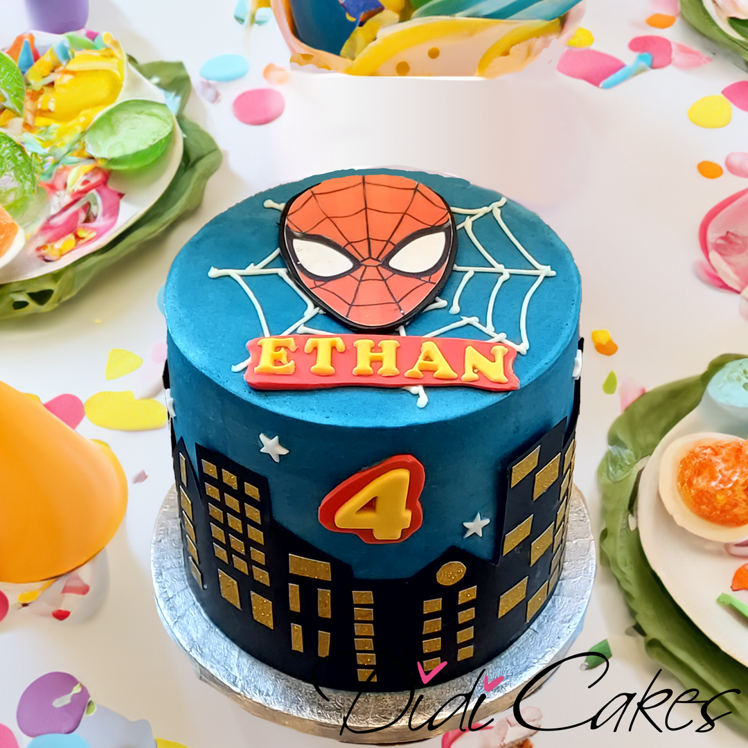 A round birthday cake decorated with Spiderman theme, featuring Spiderman's face and city skyline design, personalised with name and age.
