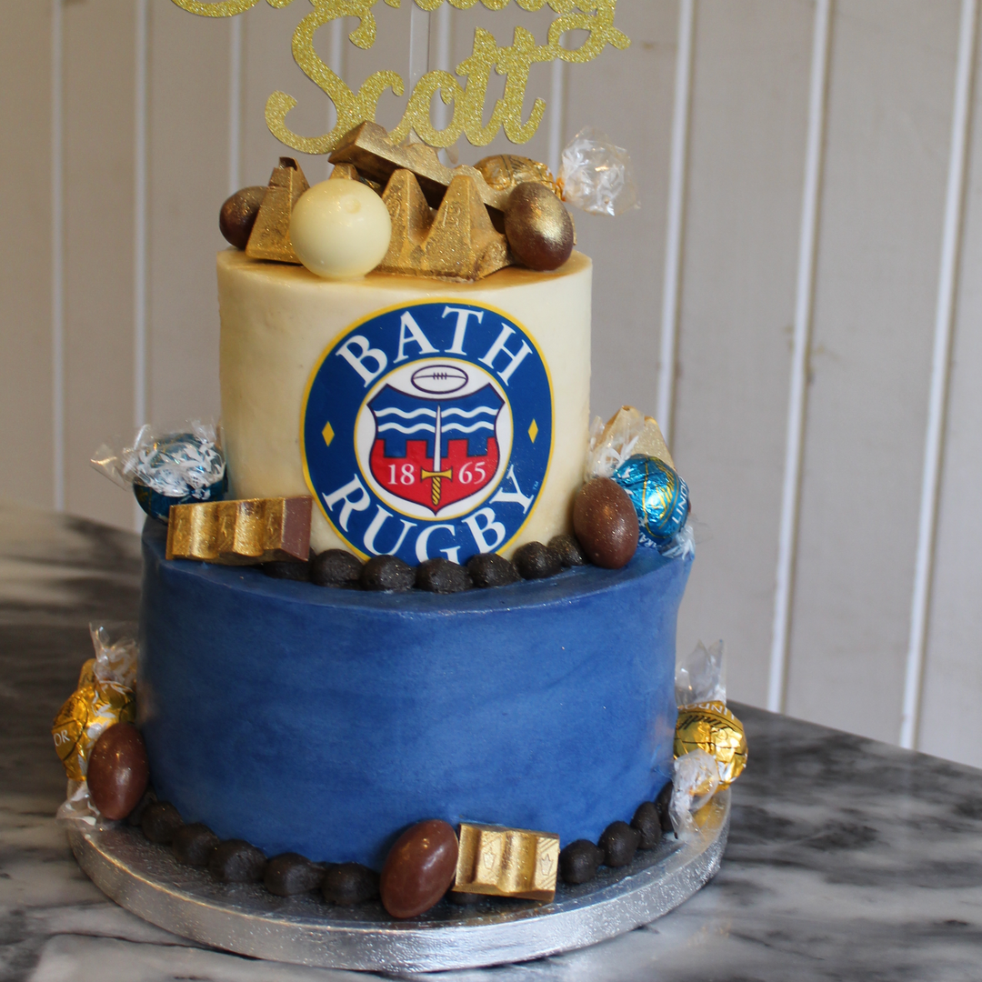 A two-tier birthday cake with premier league team colours